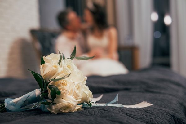 Forge Valley Event Center | Hendersonville, Brevard, Asheville | hotel room with bride and groom and bouquet on bed