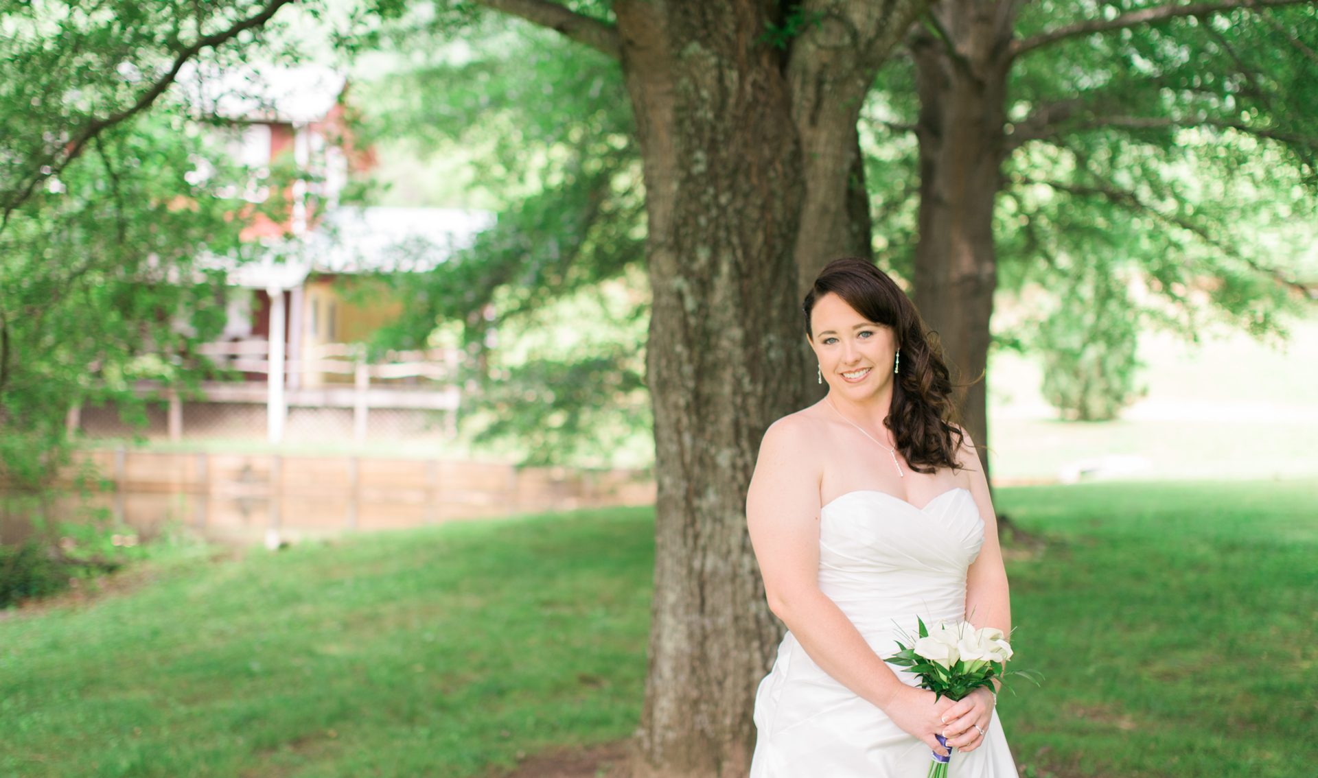 Forge Valley Event Center | Hendersonville, Brevard, Asheville | a beautiful bride with white flowers posing for photographs at forge valley event center