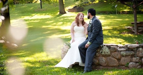 Forge Valley Event Center | Hendersonville, Brevard, Asheville | beautiful photo opportunities, bride and groom couple sitting on stone wall in our beautiful outdoor areas